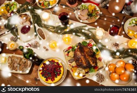 christmas dinner and eating concept - roast chicken or turkey and other food on table over snow. roast chicken or turkey on christmas table