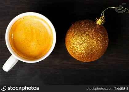 christmas eve at office, top view of coffee cup with golden ball