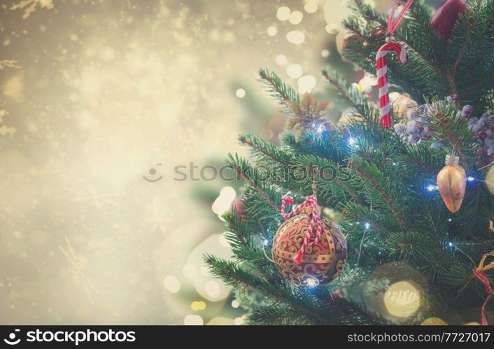 christmas evergreen fresh tree with holiday decorations and lights with copy space on silver bokeh background, retro toned. christmas fir tree with decorations