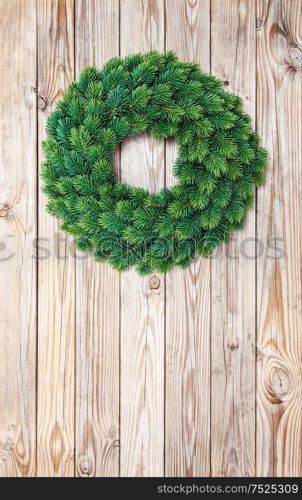 Christmas evergreen wreath decoration on rustic wooden background. Vintage style toned picture
