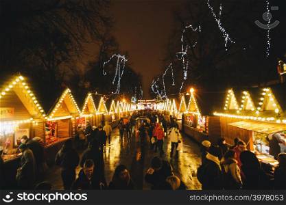Christmas fair with lot of people and lanterns at background