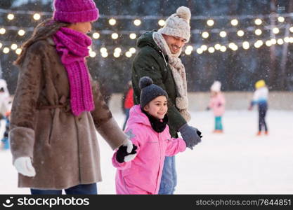 christmas, family and leisure concept - happy mother, father and daughter at outdoor skating rink in winter. happy family at outdoor skating rink in winter