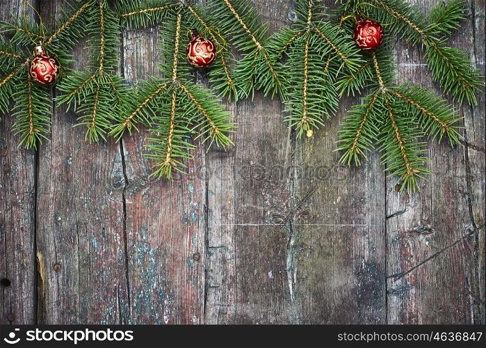 Christmas festive background with fir tree. Retro wooden background with fir tree branches and Christmas decorations.Copy space