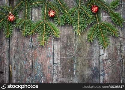 Christmas festive background with fir tree. Retro wooden background with fir tree branches and Christmas decorations.Copy space