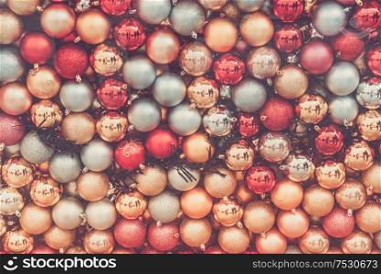 Christmas festive decorations, shining top view background, retro toned. Gray Christmas decorations on pink