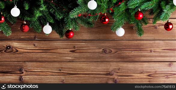 Christmas fir tree and decorative baubles on wooden background. Christmas fir tree and decor
