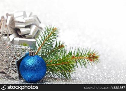 Christmas fir tree branch and decoration on silver glitter background