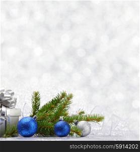 Christmas fir tree branch and decoration on silver glitter background