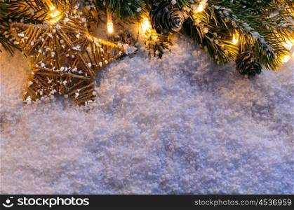 Christmas fir tree with lights and star on snow in dark, view from above