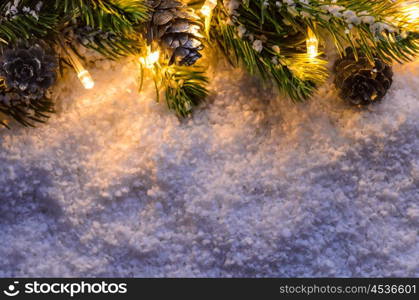 Christmas fir tree with lights on snow in dark, view from above