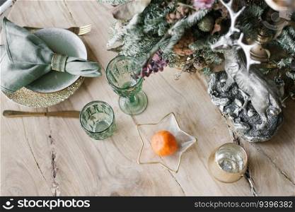 Christmas flat lay background. Cutlery with wine glasses, tangerine, fir or spruce branches. Minimalistic design. Copy space. Christmas concept.