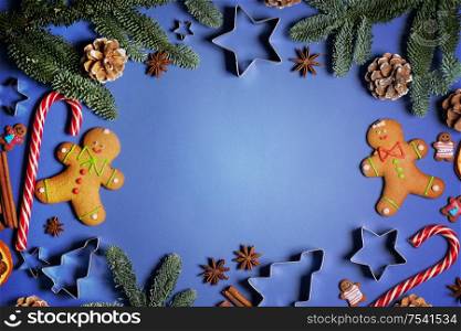 Christmas flat lay background with traditional gingerbread cookies dried orange cinnamon on blue , copy space for text. Christmas food on wood background