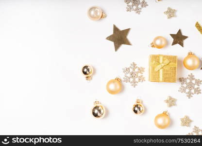 Christmas flat lay border with git box with golden bow knot on white desk, border. Christmas flat lay scene with golden decorations