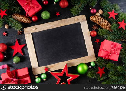 Christmas flat lay frame with red git boxes, Christmas celebration and gift giving concept, copy space on blackboard. Christmas flat lay scene with golden decorations
