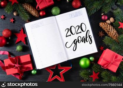 Christmas flat lay frame with red git boxes, Christmas celebration and gift giving concept, with happy new 2020 year greetings in notebook. Christmas flat lay scene with golden decorations