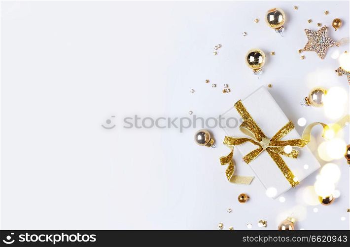 Christmas flat lay scene with git box with golden bow knot. Christmas flat lay scene with golden decorations