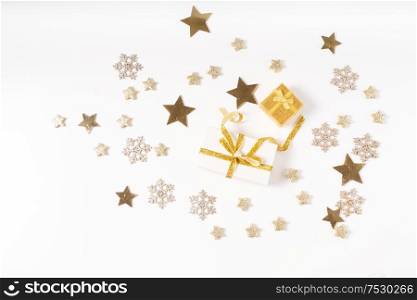 Christmas flat lay scene with git box with golden bow knot, copy space over white desk background. Christmas flat lay scene with golden decorations