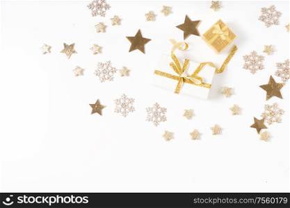 Christmas flat lay scene with git box with golden bow knot, copy space on white desk background. Christmas flat lay scene with golden decorations