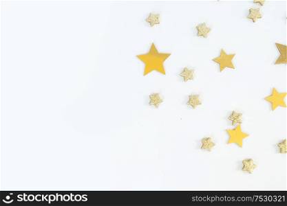 Christmas flat lay scene with golden stars and decorations, top view over white. Christmas flat lay scene with golden decorations