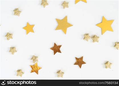 Christmas flat lay scene with golden stars over white, top view. Christmas flat lay scene with golden decorations
