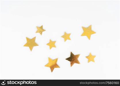 Christmas flat lay scene with golden stars, top view over white. Christmas flat lay scene with golden decorations