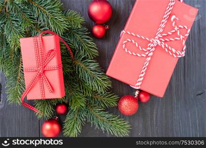 Christmas flat lay scene with red git box and green evergreen twigs, Christmas celebration and gift giving concept. Christmas flat lay scene with golden decorations