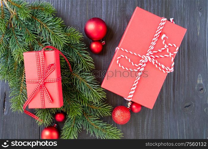 Christmas flat lay scene with red git box and green evergreen twigs, Christmas celebration and gift giving concept. Christmas flat lay scene with golden decorations