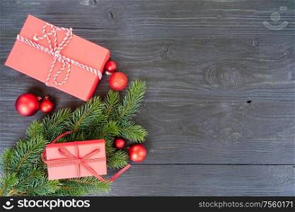 Christmas flat lay scene with red git boxes and green twigs, Christmas celebration and gift giving concept, copy space on wooden background. Christmas flat lay scene with golden decorations