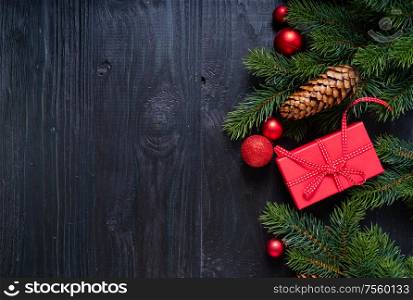 Christmas flat lay scene with red present boxes and green twigs, Christmas celebration and gift giving concept, copy space on wooden background. Christmas flat lay scene with golden decorations