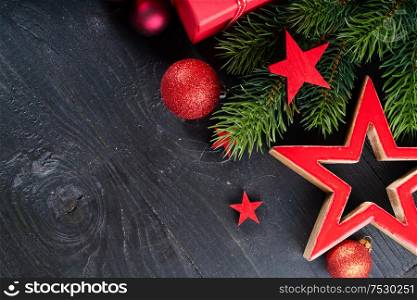 Christmas flat lay scene with red stars, Christmas celebration and gift giving concept, copy space on wooden black background. Christmas flat lay scene with golden decorations