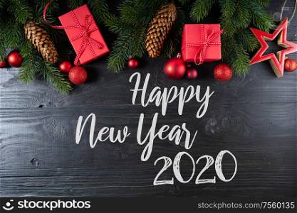 Christmas flat lay scene with red stars, Christmas celebration and gift giving concept, copy space on black background with happy new 2020 year greetings. Christmas flat lay scene with golden decorations