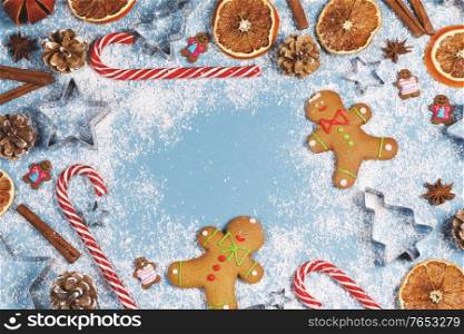Christmas food frame. Gingerbread cookies, spices and decorations on blue background with copy space for text. Christmas food frame
