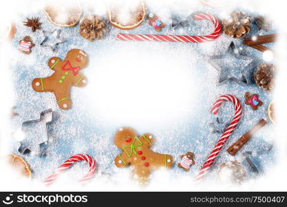 Christmas food frame. Gingerbread cookies, spices and decorations on blue background with copy space. Christmas food frame