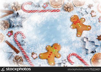 Christmas food frame. Gingerbread cookies, spices and decorations on blue background with copy space. Christmas food frame