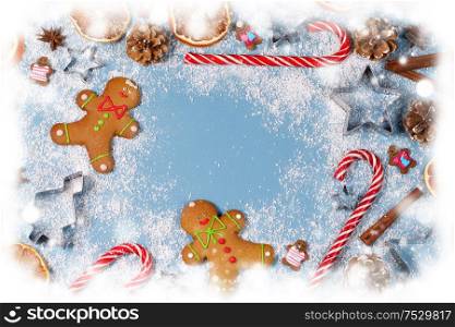Christmas food frame. Gingerbread cookies, spices and decorations on blue background with copy space. Christmas food frame