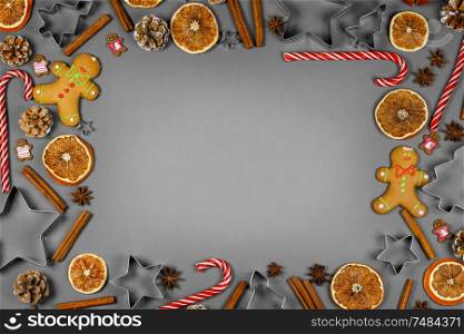 Christmas food frame. Gingerbread cookies, spices and decorations on gray background with copy space. Christmas food frame