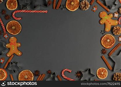 Christmas food frame. Gingerbread cookies, spices and decorations on gray background with copy space. Christmas food frame