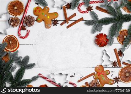 Christmas food frame. Gingerbread cookies, spices and decorations on wooden background with white copy space on white snow. Christmas food frame