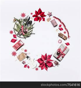 Christmas frame composition made with festive decoration objects lake Christmas wreath on white background , top view. Flat lay. Festive layout with poinsettia, gift box, festive table setting