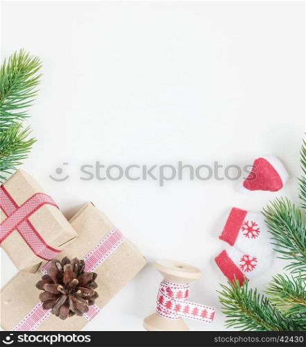 Christmas frame, consisting of fir branches, cones and gift boxes tied with ribbons on a white background with space for text. Flat lay composition for greeting cards, websites, social media, magazines, bloggers, artists etc. Christmas wallpaper
