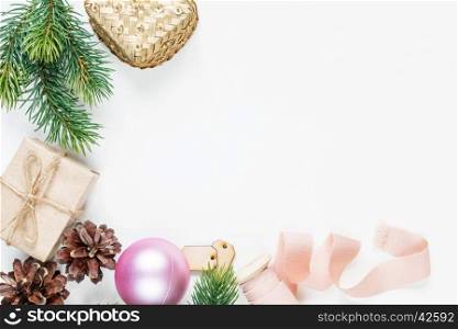 Christmas frame, consisting of fir branches, cones, gift boxes, Christmas ball and a pink ribbon on a white background with space for text. Flat lay composition for greeting cards, websites, social media, magazines, bloggers, artists etc. Christmas wallpaper