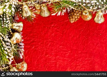 Christmas frame from branch and bells on red paper background