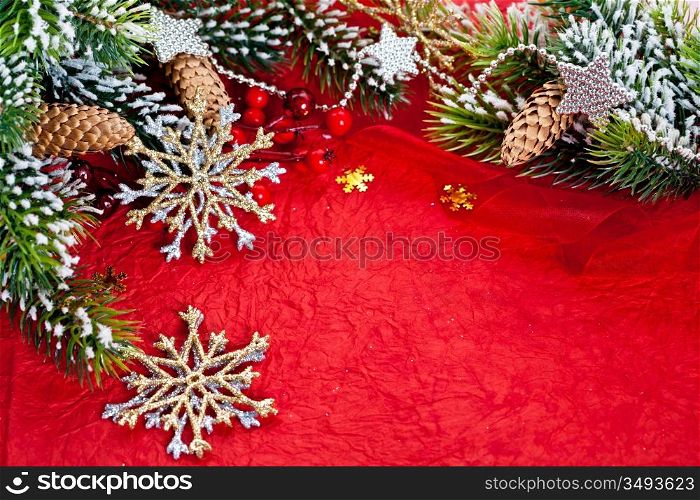 Christmas frame from branch and decorations on red paper background