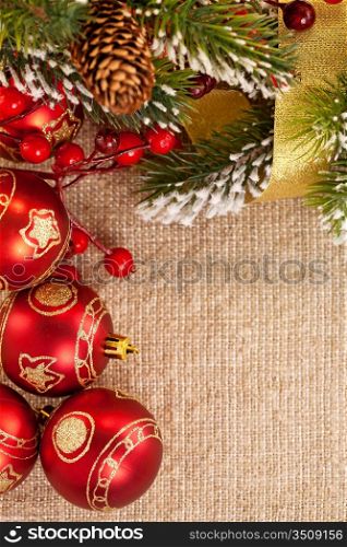 Christmas frame with branch and decorations on burlap background
