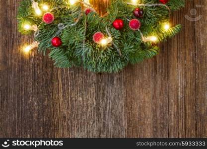 christmas fresh green wreath with lights, copy space on wooden table