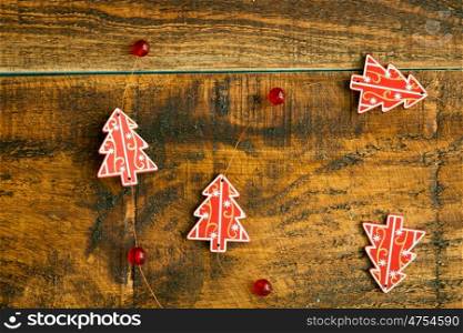 Christmas garland of small wooden firs on a rustic background