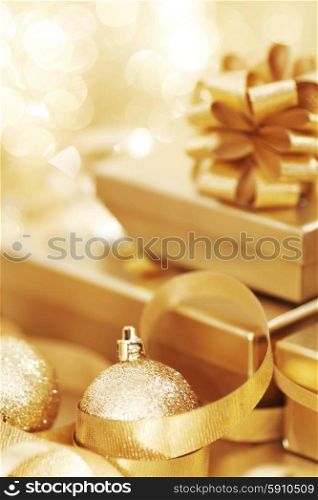 Christmas gift and balls. Golden christmas gift box and christmas balls on bokeh light background
