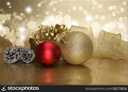 Christmas gift and baubles on a gold starry background