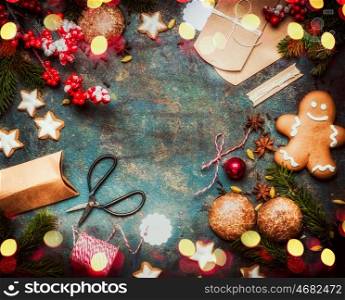 Christmas gift and presents wrapping with holiday cookies and handmade paper boxes on dark vintage background with festive bokeh lighting, top view, frame