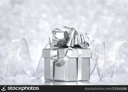 Christmas gift box with decoration on shiny background